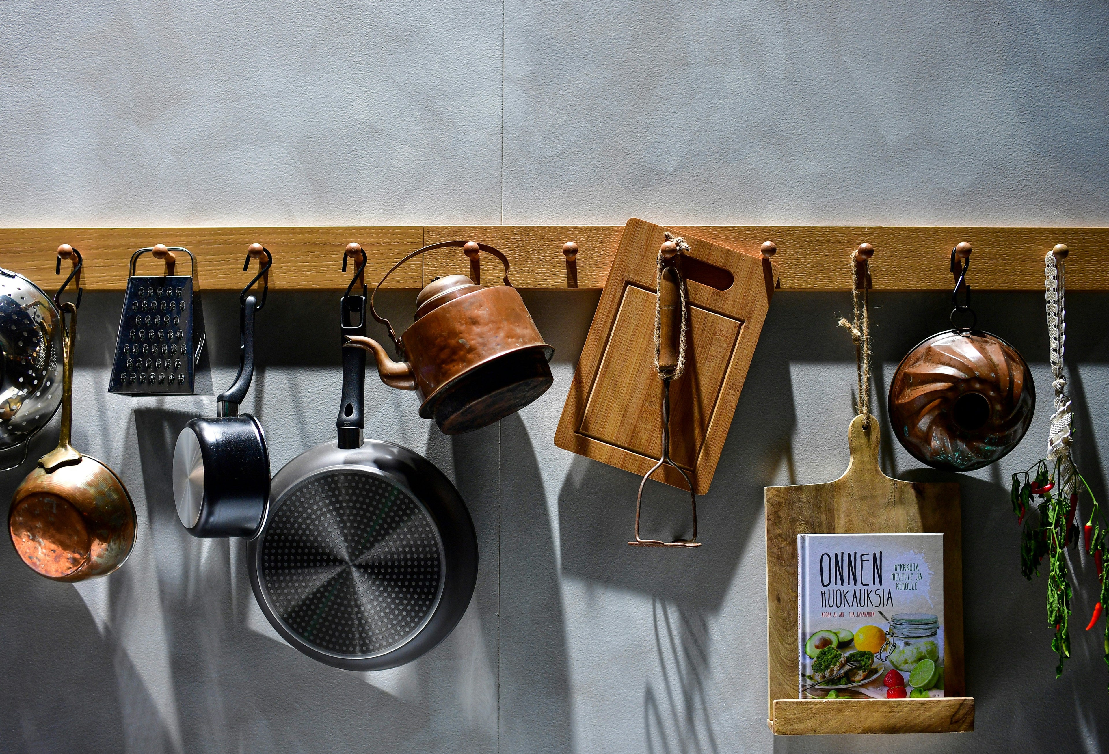 Cooking tools such as spatula, whisk, tongs, and measuring cups on a modern kitchen counter